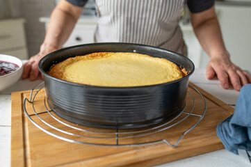 Fresh baked cheesecake in a round baking pan 