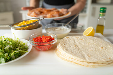 Preparing healthy wraps in the kitchen by a woman with apron