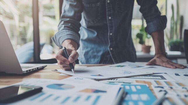 A business owner setting clear business goals with a detailed action plan, with goal-setting worksheets, a vision board, and strategic plans on the desk, illustrating the importance of defining clear