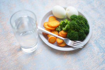 A breakfast diet plate without rice, featuring eggs, carrots, and broccoli, promoting a healthy and balanced meal