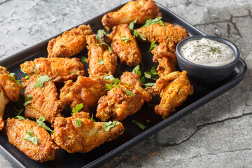 Homemade baked chicken wings breaded with curry close-up in a plate on the table. Horizontal