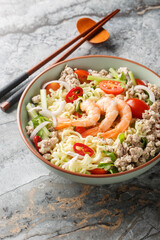 Yum Mama Thai Instant Noodle Salad closeup on the plate on the marble table. Vertical