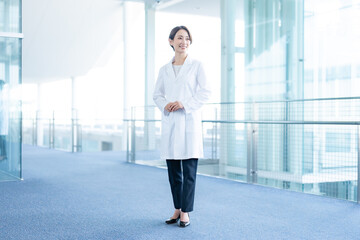 室内に立つ白衣を着た笑顔の医療従事者