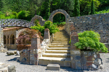 Stone staircase and arched bridge leading to a gazebo in the courtyard of the Ortubani Monastery.