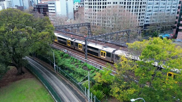 Landscape view of commuter train moving along railway tracks with buildings pathway Central Station Surry Hills Australia travel transport interchange
