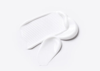 samples of cosmetic care products smear of cream texture on a light background