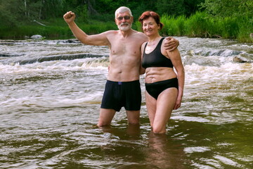 Fototapeta premium sports elderly couple bathes in the mountain river Sakmara in the Southern Urals