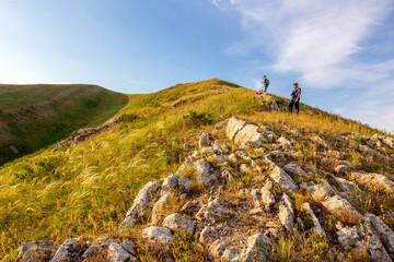 tourists men and women walk along the ridges of the Southern Urals on a summer day. Karamuruntau ridge,