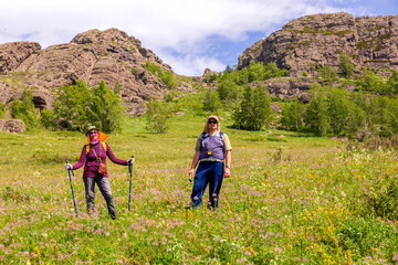 tourists men and women walk along the ridges of the Southern Urals on a summer day. Irendyk ridge