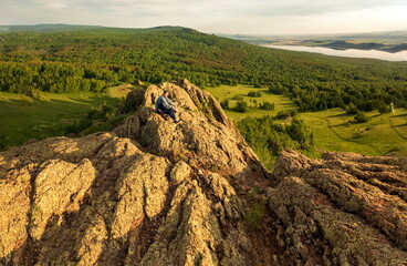 Naklejka premium a young handsome man travels through the mountains of the Southern Urals on a summer day