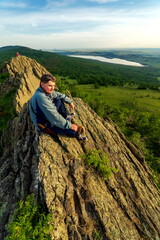 Naklejka premium a young handsome man travels through the mountains of the Southern Urals on a summer day