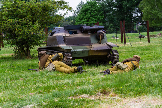 Historical reconstruction. Polish defensive war 1939. Battle of Wyry. Polish infantry soldiers fight on the battlefield under the cover of a tankette. View from the back. Wyry, Silesia, Poland