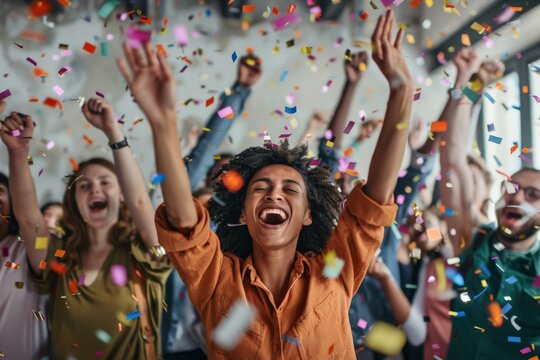 Happy diverse employees team celebrating success business achievement among confetti.