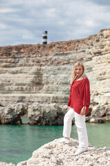 Fototapeta na wymiar middle aged woman posing in the sea. The mature lady enjoy the freedom of the beach