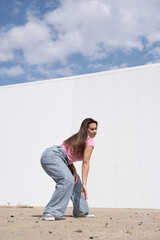 plus size woman wearing casual clothes dancing on white wall background in the street