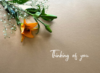 Sympathy Card with Orange Lily and Green Leaves on Beige Background - Thinking of You Message.