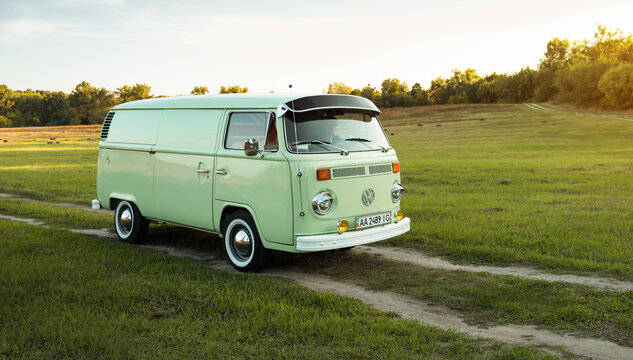 Green classic Volkswagen Transporter bus on countryside unpaved road, front three quarter view. Kyiv region, Ukraine - September 15 2015.