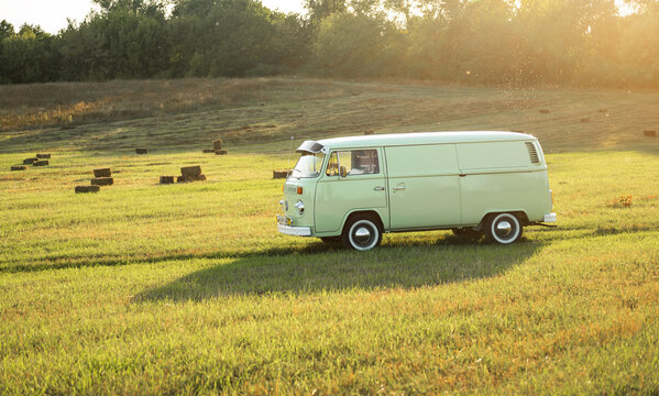 Green classic Volkswagen Transporter van on countryside unpaved road, side view. Kyiv region, Ukraine - September 15 2015.