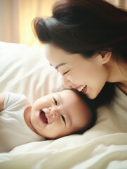 A mother and her baby lying together on a bed