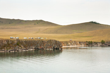 Baikal Lake in summer. A group of retired tourists travel around Olkhon Island in motor homes and...