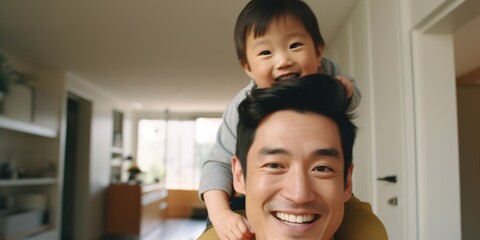 A father holds his young child on his shoulders, showing love and care