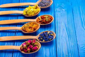 Assortment of dry herbal and berry tea on a wooden background. Tea party concept. medicinal herbs. Healing herbs.Alternative medicine.Linden, calendula, cornflowers, marigold, tansy, tea rose.