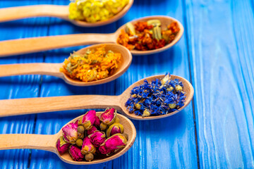 Assortment of dry herbal and berry tea on a wooden background. Tea party concept. medicinal herbs. Healing herbs.Alternative medicine.Linden, calendula, cornflowers, marigold, tansy, tea rose.