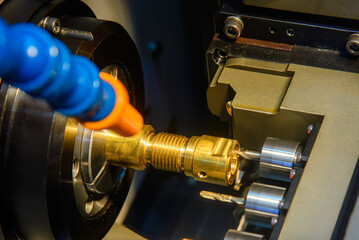 The  multi tasking CNC lathe machine swiss type drilling the brass fitting parts.