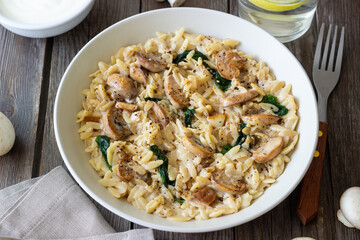 Orzo pasta with mushrooms and spinach. Italian Cuisine. Vegetarian food.