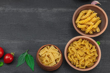 Pasta. Various kinds of uncooked pasta and noodles over wooden background. Traditional Italian