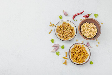 Pasta. Various kinds of uncooked pasta and noodles over light stone background. Traditional Italian