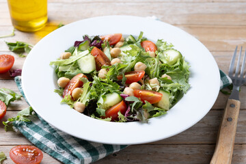 Healthy chickpea salad with tomato,lettuce and cucumber on wooden table