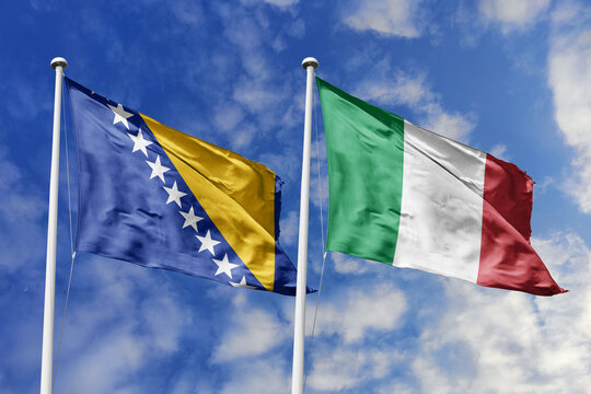 3D illustration. Bosnia and Herzegovina and Italy flags waving in the sky. High detailed waving flag. 3D render. Flags fluttered in the cloudy sky, symbolizing diplomatic relations.