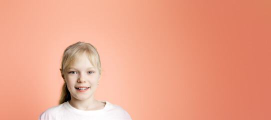 Portrait of a smiling blonde girl in a white T-shirt, space for text