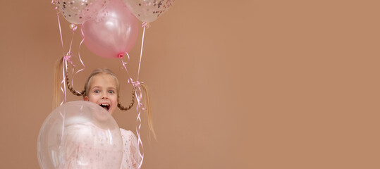 Banner blonde girl with pigtails with pink balloons on a brown background. Copy space.