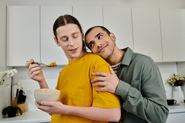 A young gay couple enjoys breakfast in their modern apartment, sharing a tender moment with a hug.