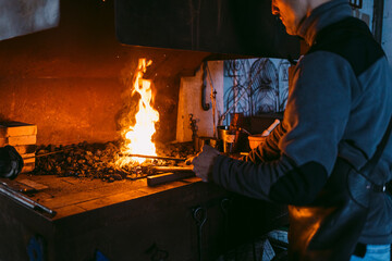 Blacksmith Heating Metal in Forge at Workshop