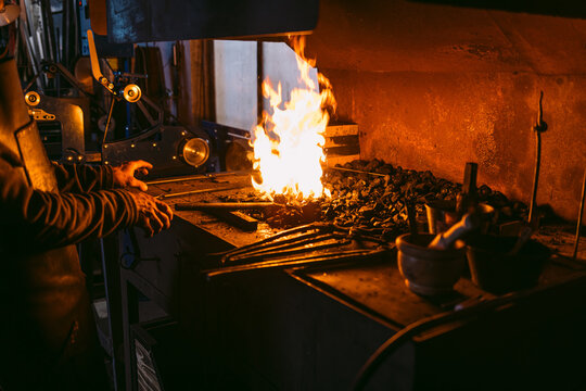 Traditional blacksmith working with hot furnace - Powered by Adobe