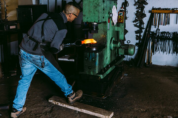 Skilled Blacksmith Forging Metal with Power Hammer