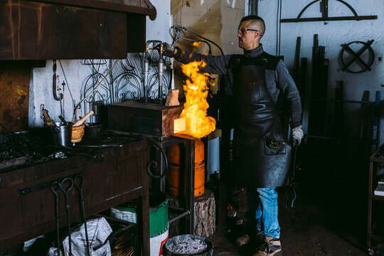 Blacksmith working with molten metal in forge