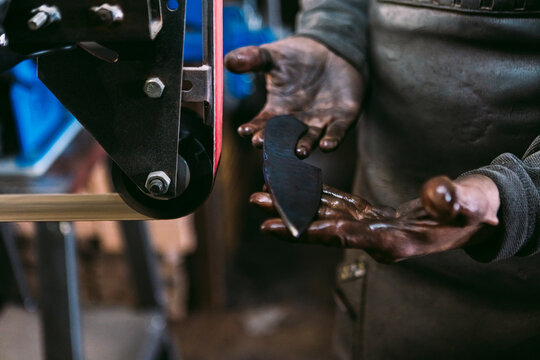 Blacksmith Sharpening a Blade on Grinding Wheel