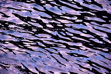 Fluid patterns of a purple and black water surface of the Cantabrian Sea