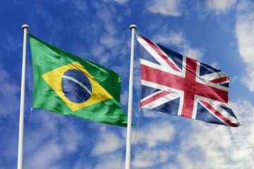 A Brazilian and UK flag, a metaphor for cultural exchange, wave together against a blue sky, symbolizing alliance and mutual respect.