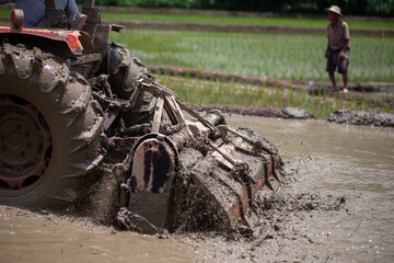 Obraz premium selective tractor plowing soil in rice fields It's about to be rice planting season in the rice fields. It's almost rainy season in the rice fields of