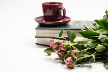 Books and flowers on a white background,Beautiful pink flowers and cup of coffee on a stack of books. 