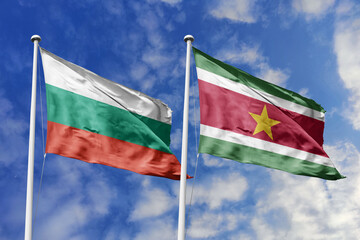 3D illustration. Bulgaria and Suriname Flag waving in the sky. High detailed waving flag. 3D render. Waving in the sky. Flags fluttered in the cloudy sky.