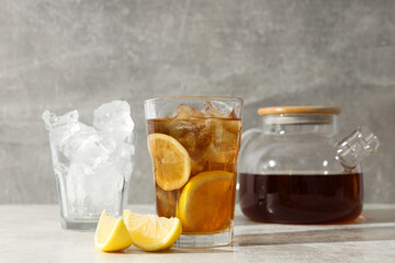 A glass of cold tea with ice and an orange