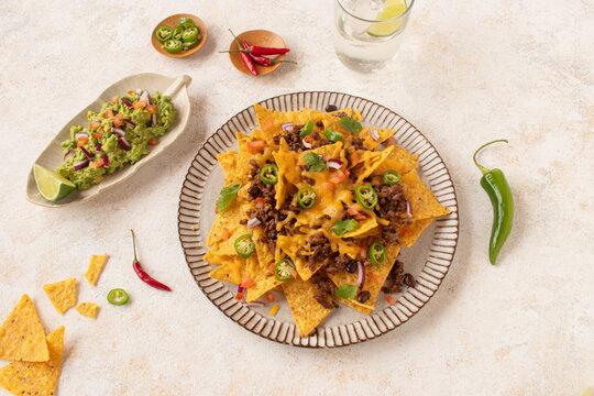 Top view of delicious nachos with guacamole and toppings