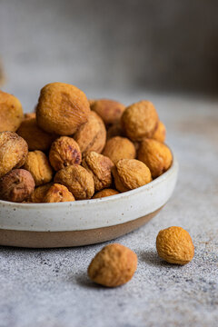 Sun-dried Arashan Kandak apricots in a ceramic bowl