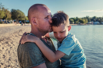 Fototapeta premium Photo of smiling boy and his dad at the beach.